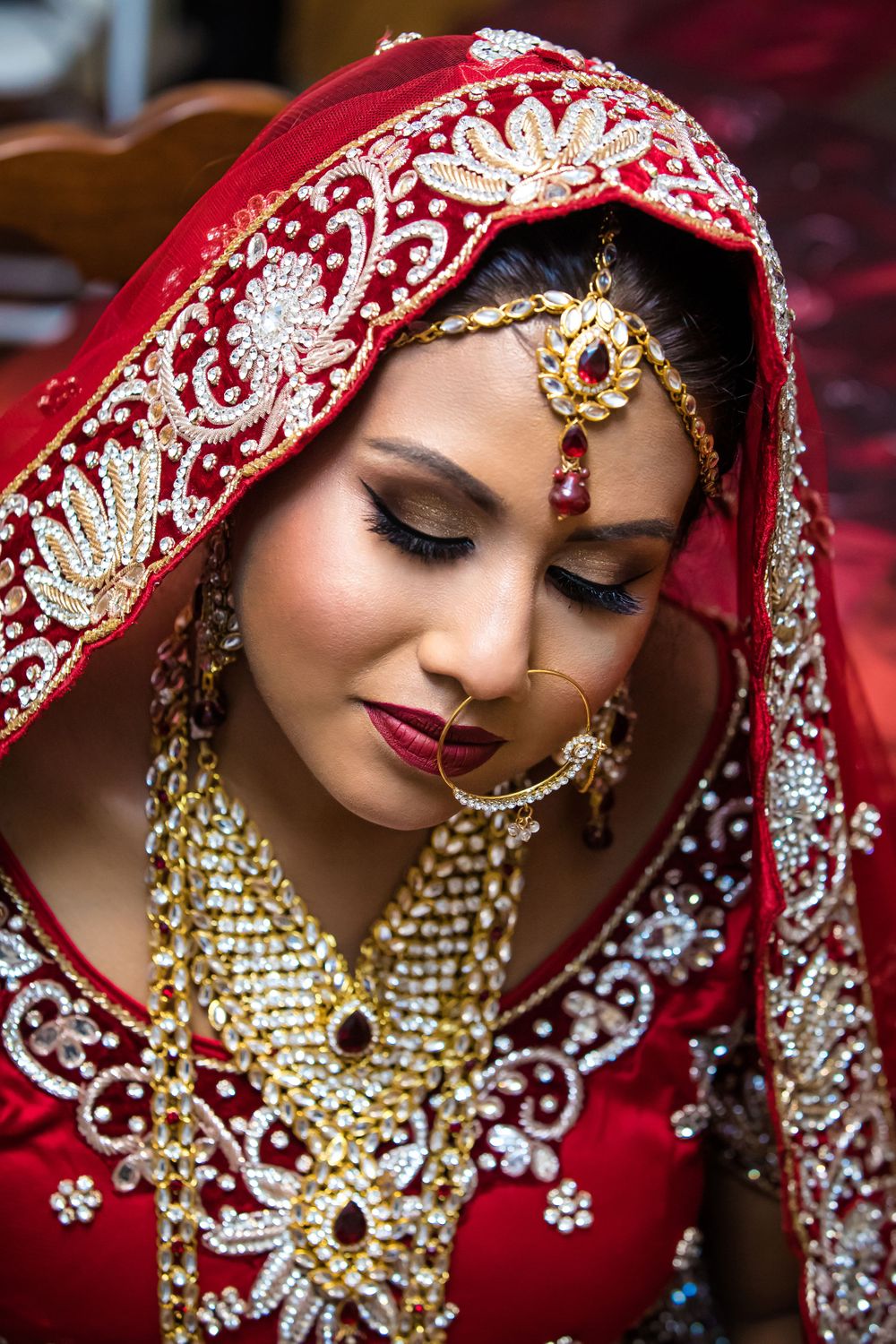 Artistic close-up of Indian bridal jewelry and makeup details.