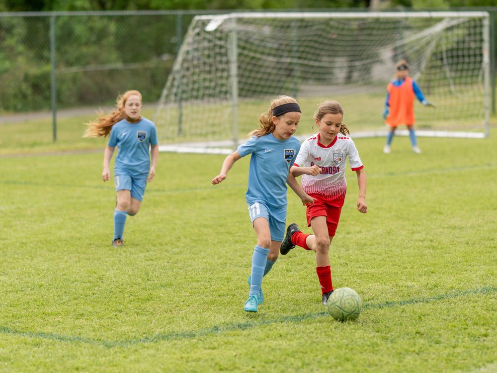 Young soccer players battling for possession during competitive match.