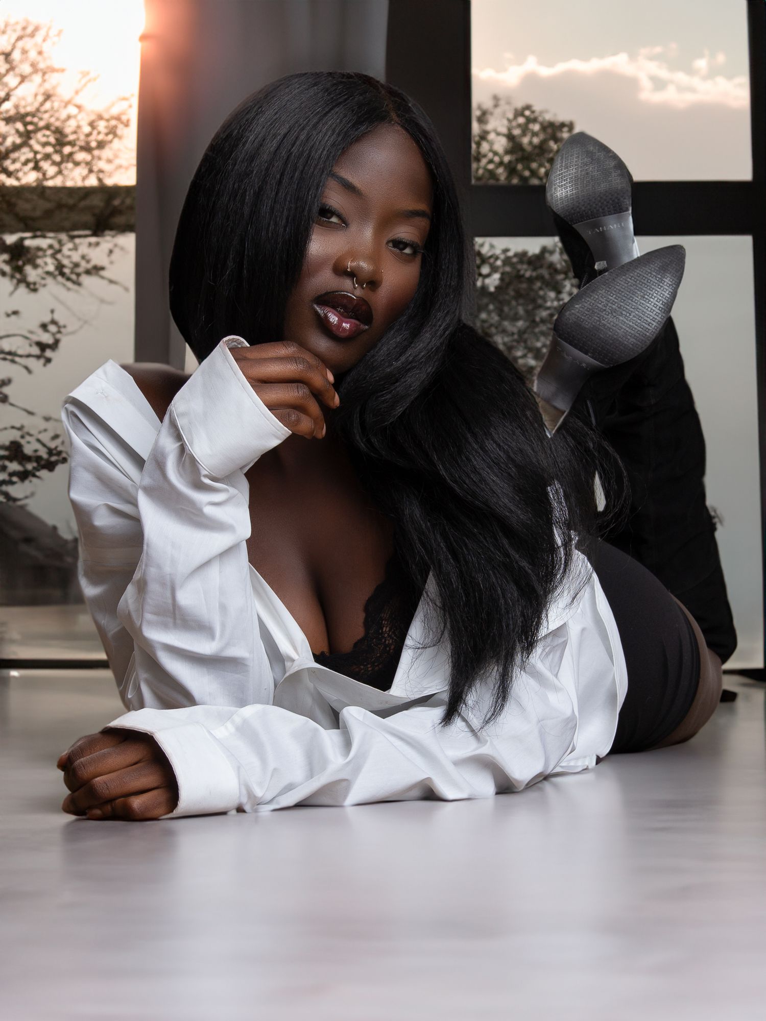 Fashion portrait session with model in white shirt on hardwood floor.