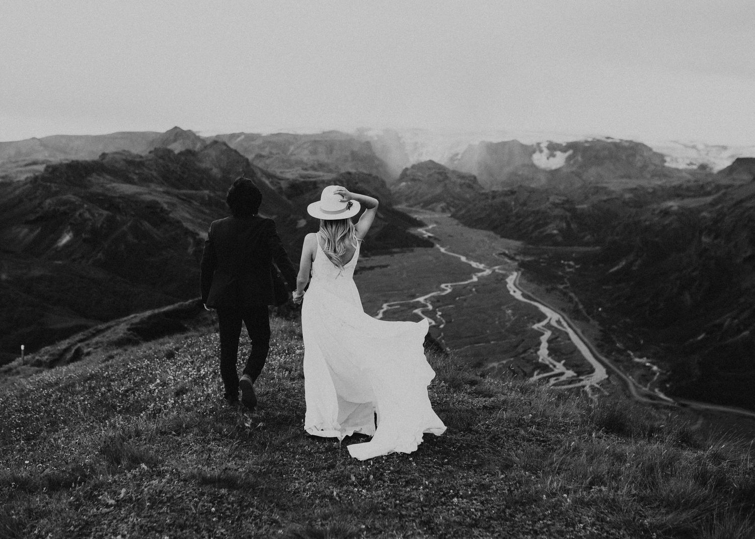 Elopement couple atop mountain overlooking glacial rivers in Iceland