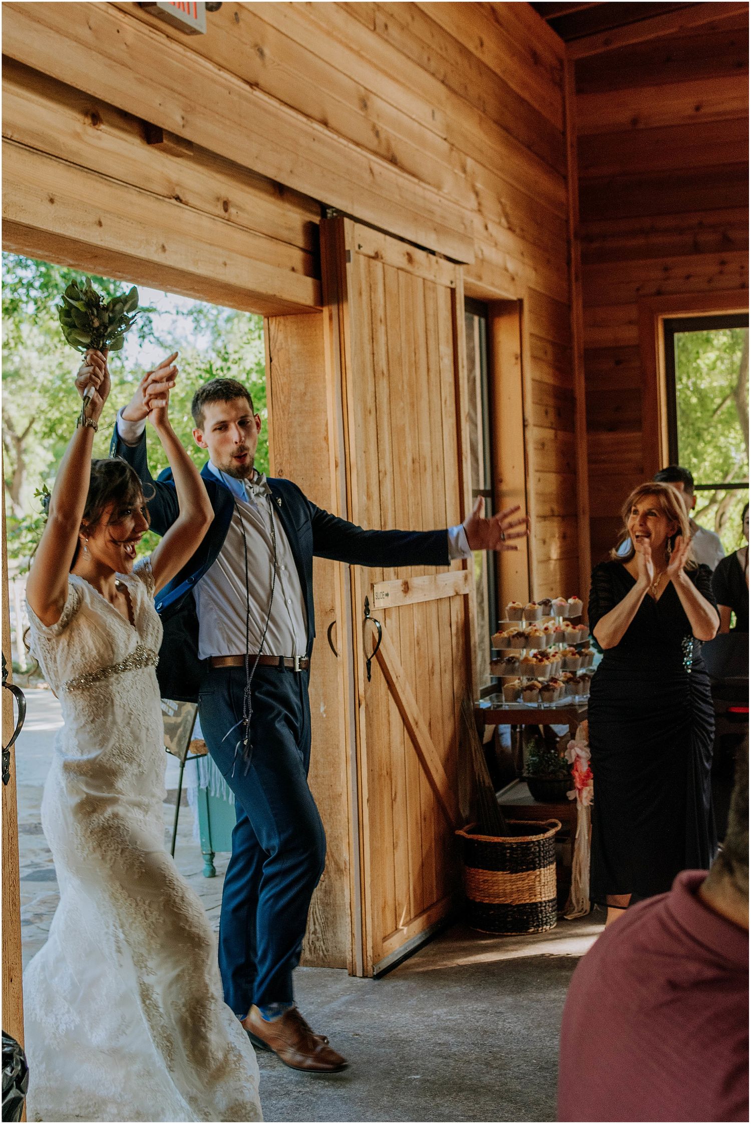 Joyful celebration inside a rustic wooden barn during a wedding reception.