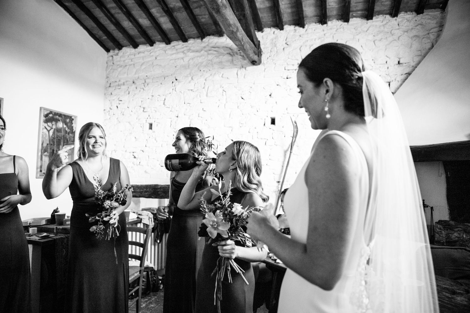 A bridesmaid take a swig out of a Prosecco bottle while getting ready.