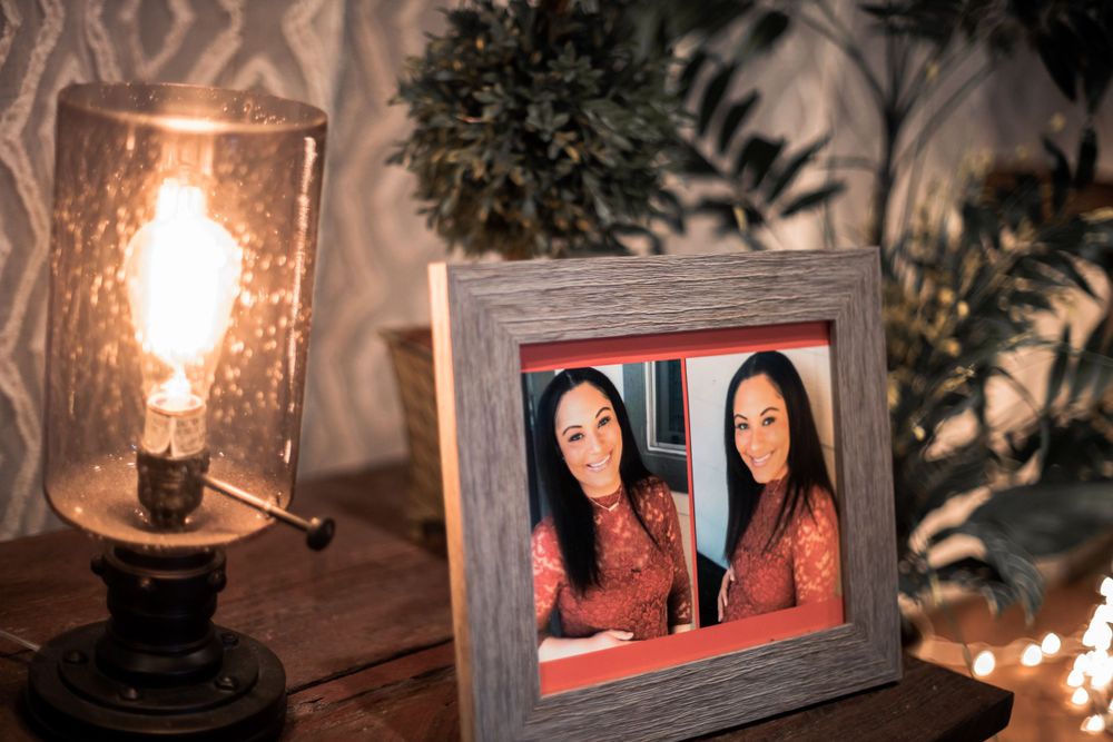 Framed photos beside vintage-style lamp creating cozy ambiance with warm lighting.