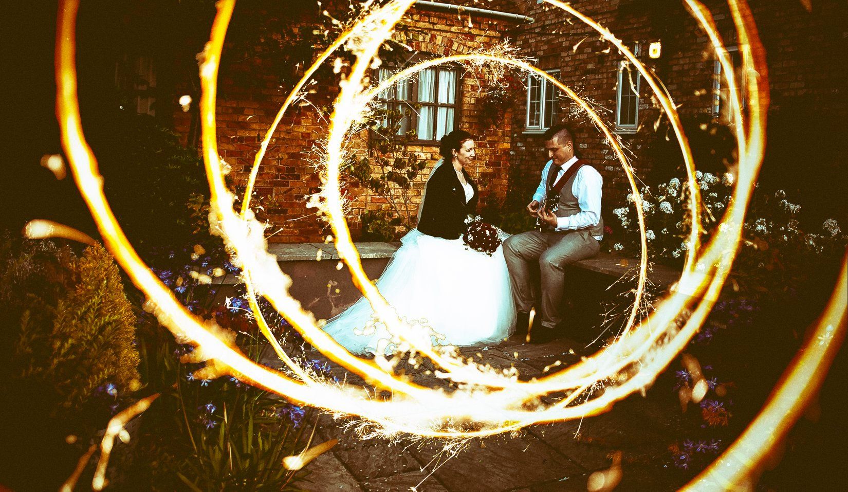 Wedding couple captured through a creative light painting effect creating a glowing circular frame.
