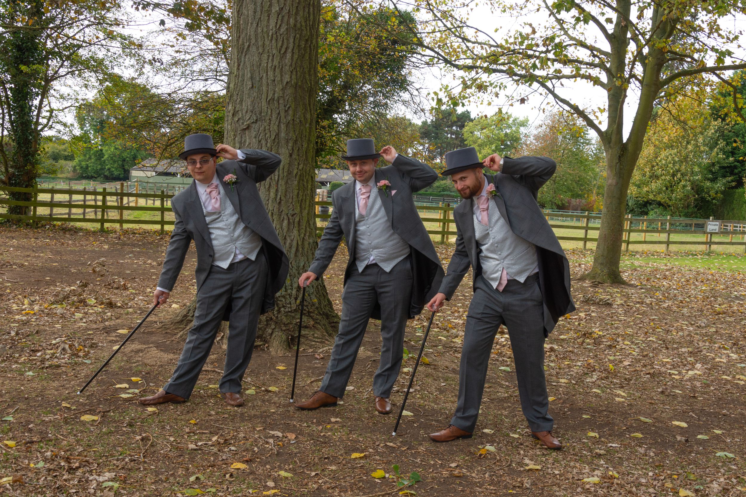 Groomsmen perform synchronized dance moves in matching suits and hats.
