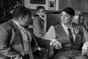 Two people in formal vests having an emotional conversation in black and white.