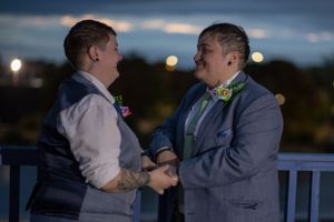 Two people share an intimate moment on a balcony at dusk.