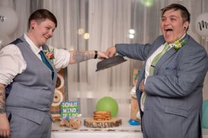 Two people share a celebratory fist bump at a reception.