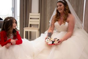 A bride in a flowing white ballgown shares a sweet moment with her companion.