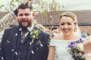 Wedding couple showered with confetti during outdoor celebration.
