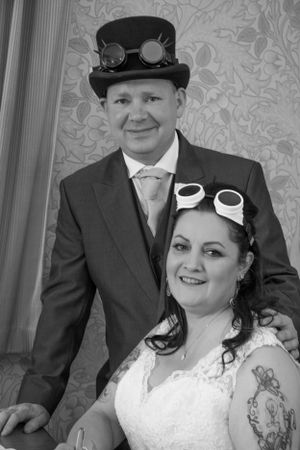 A steampunk-themed wedding portrait featuring a couple wearing Victorian-inspired accessories.
