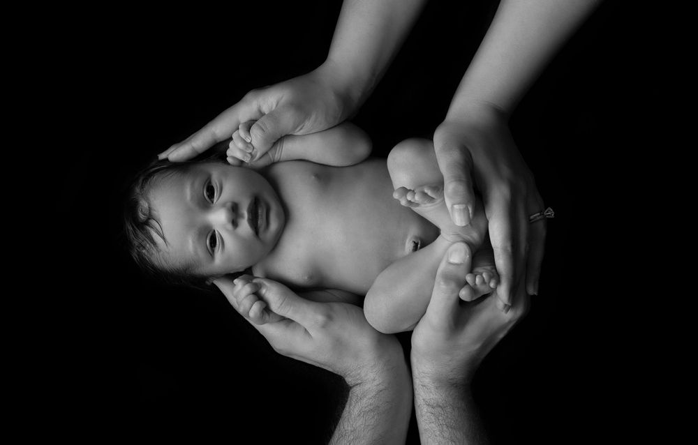 safely posed in mum and dads hands