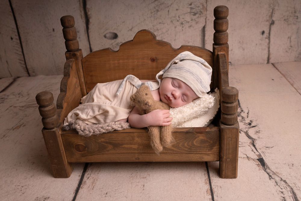 simple posed on baby's hand in bed prop with teddy prop