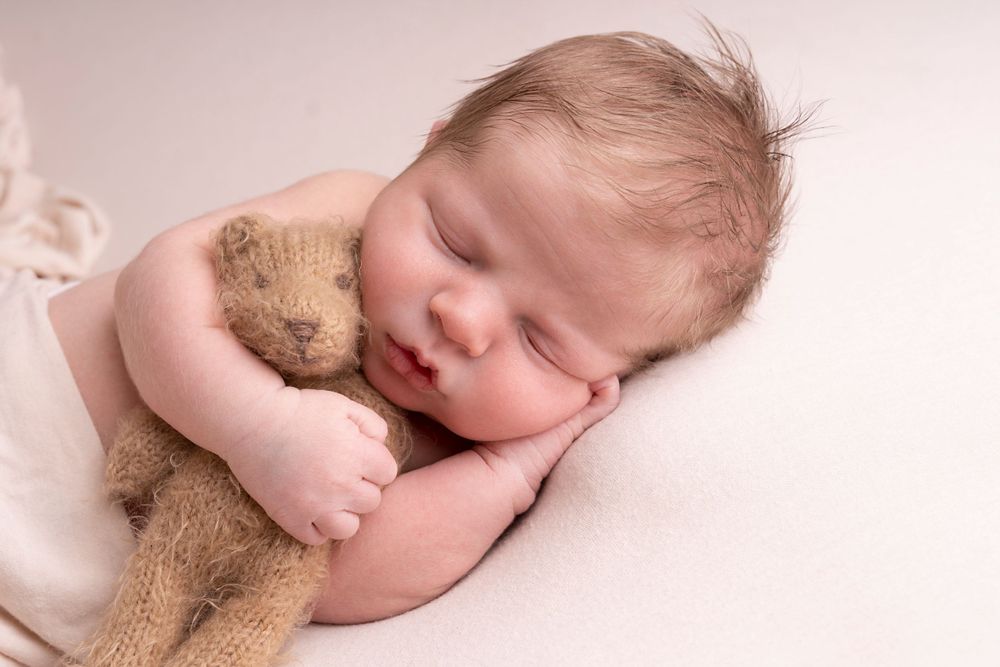simple posed on baby's hand with teddy and