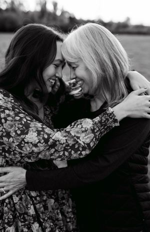 Black and white photo of two people sharing a joyful embrace outdoors.