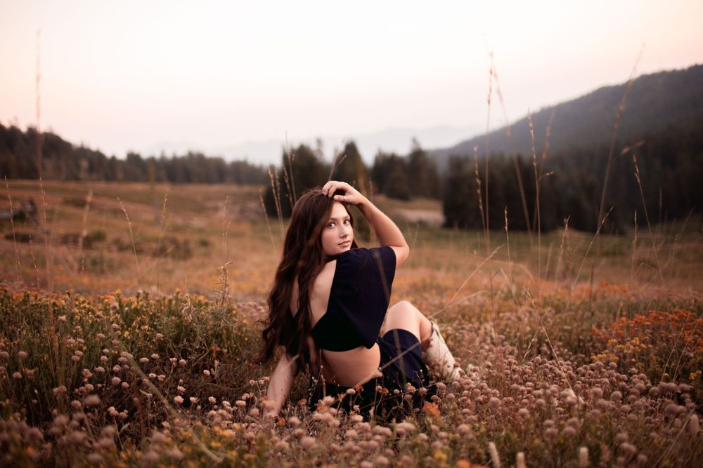 A romantic autumn portrait in a field of wildflowers during golden hour.