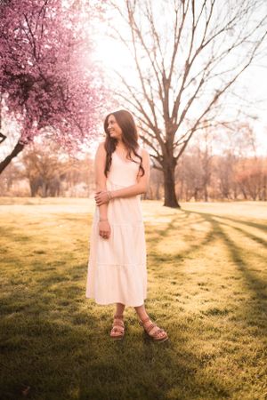 Spring portrait in a park with blooming cherry blossoms and soft afternoon light.