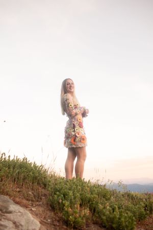 A carefree summer portrait on a hilltop overlooking mountain views at sunset.