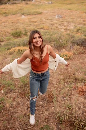 Casual autumn portrait with flowing cardigan and distressed jeans on mountain trail.