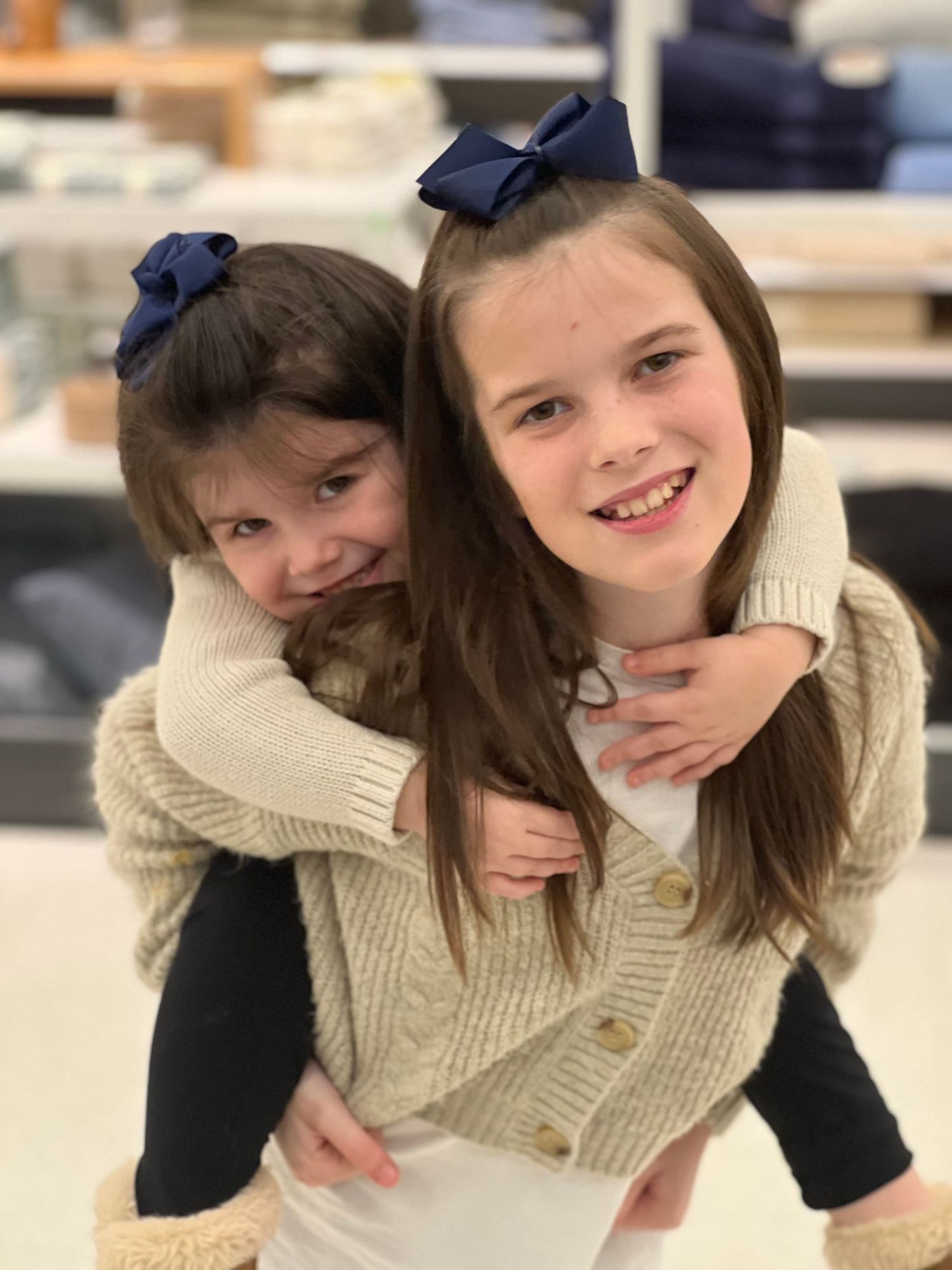 Sweet sibling moment showing playful affection and matching bows.