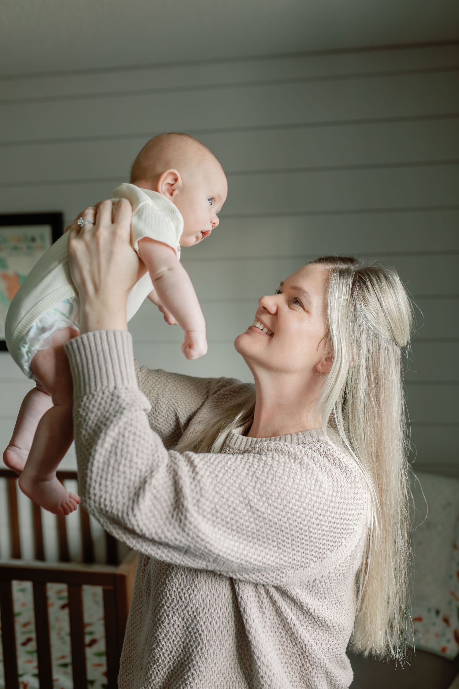 Captivating newborn session by Katie Crane Photography, showcasing a mother and newborn joyfully holding their baby and