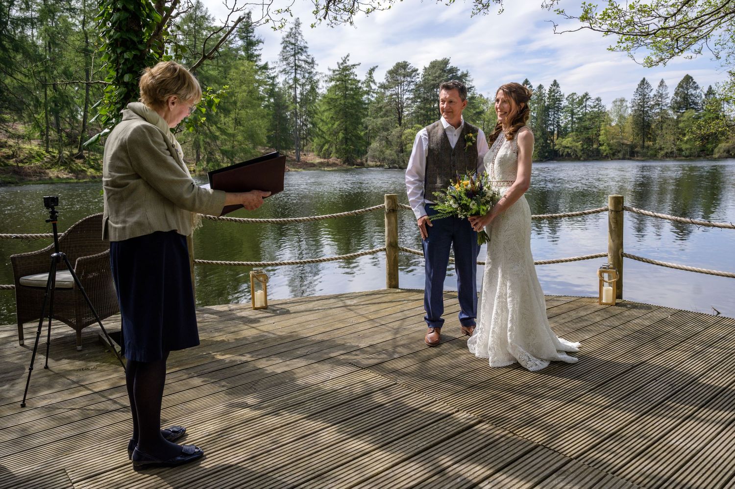 Bride and groom getting married outdoors by lake at Gilpin Lake House