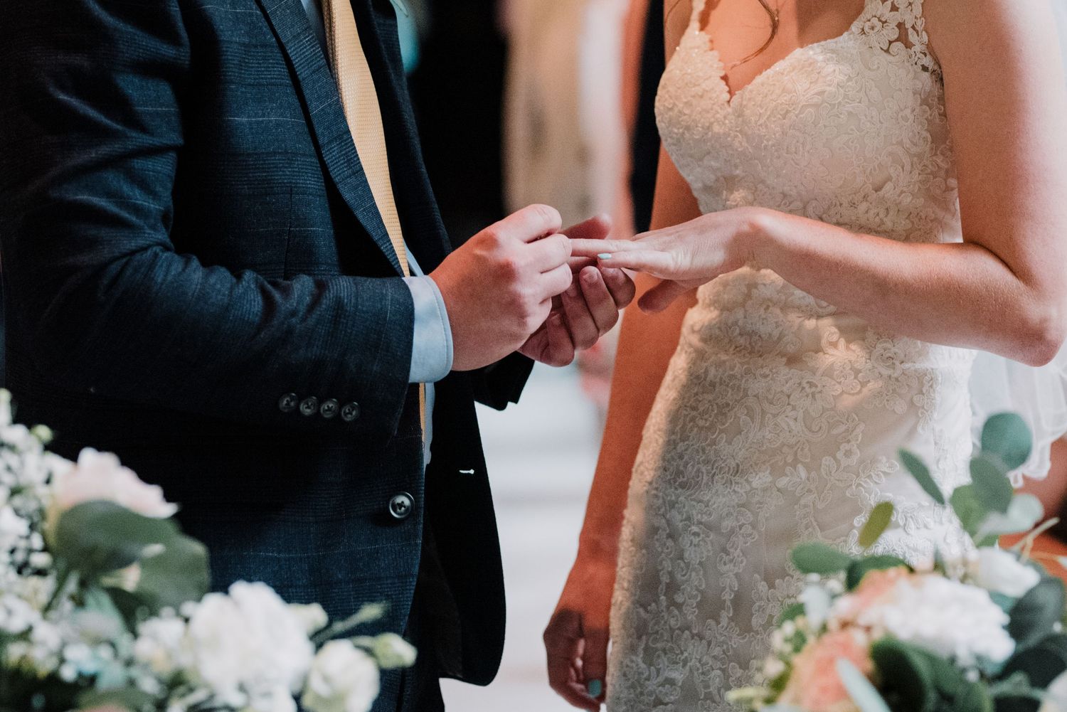 Close-up of couple exchanging rings during wedding ceremony.