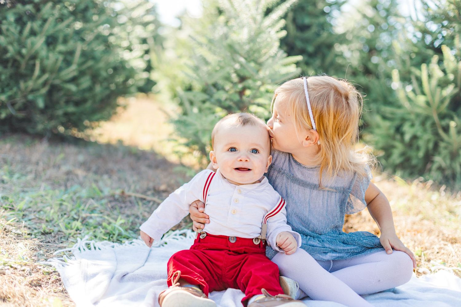 Siblings elegantly dressed in classic holiday attire, radiating joy during family photos in the Hudson Valley.