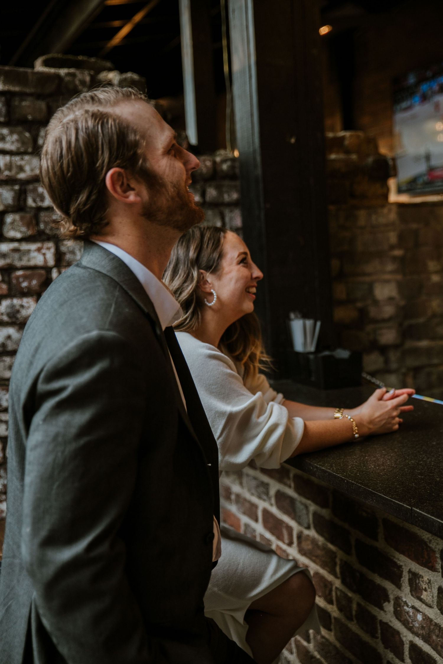 A couple smiles while ordering at a bar