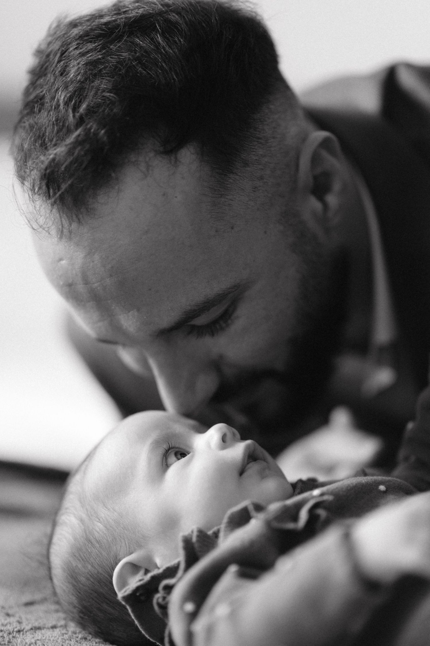 Intimate monochrome portrait of tender parenting moment.