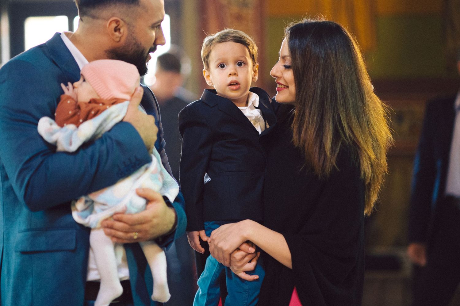 Family gathered for religious ceremony inside historic church interior.
