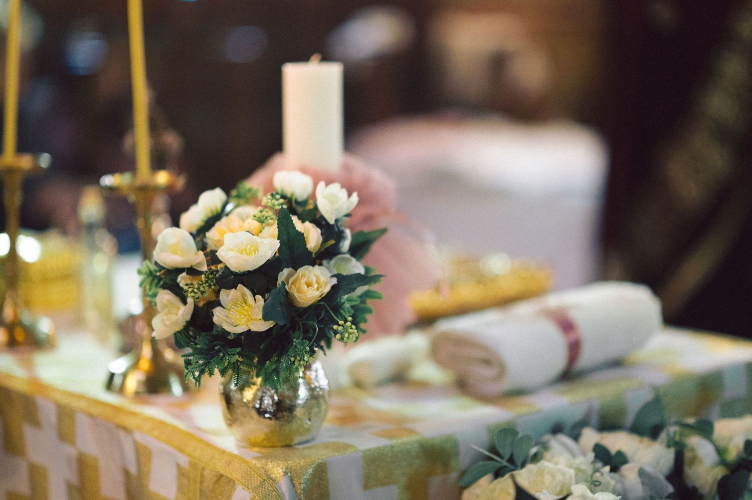 Elegant floral centerpiece with roses and candles on a decorated table.