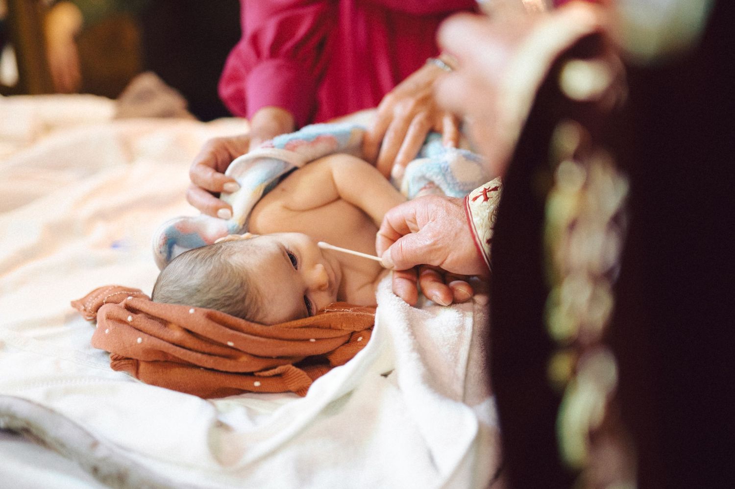 A baby lying peacefully during a traditional baptism ceremony.