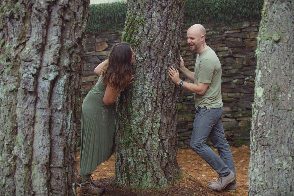 Happy engaged couple playing in the woods.