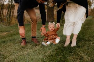 Row of feet showing different styles of footwear on grass.
