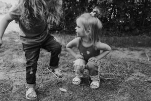 Black and white photo of children playing outdoors on rocks.