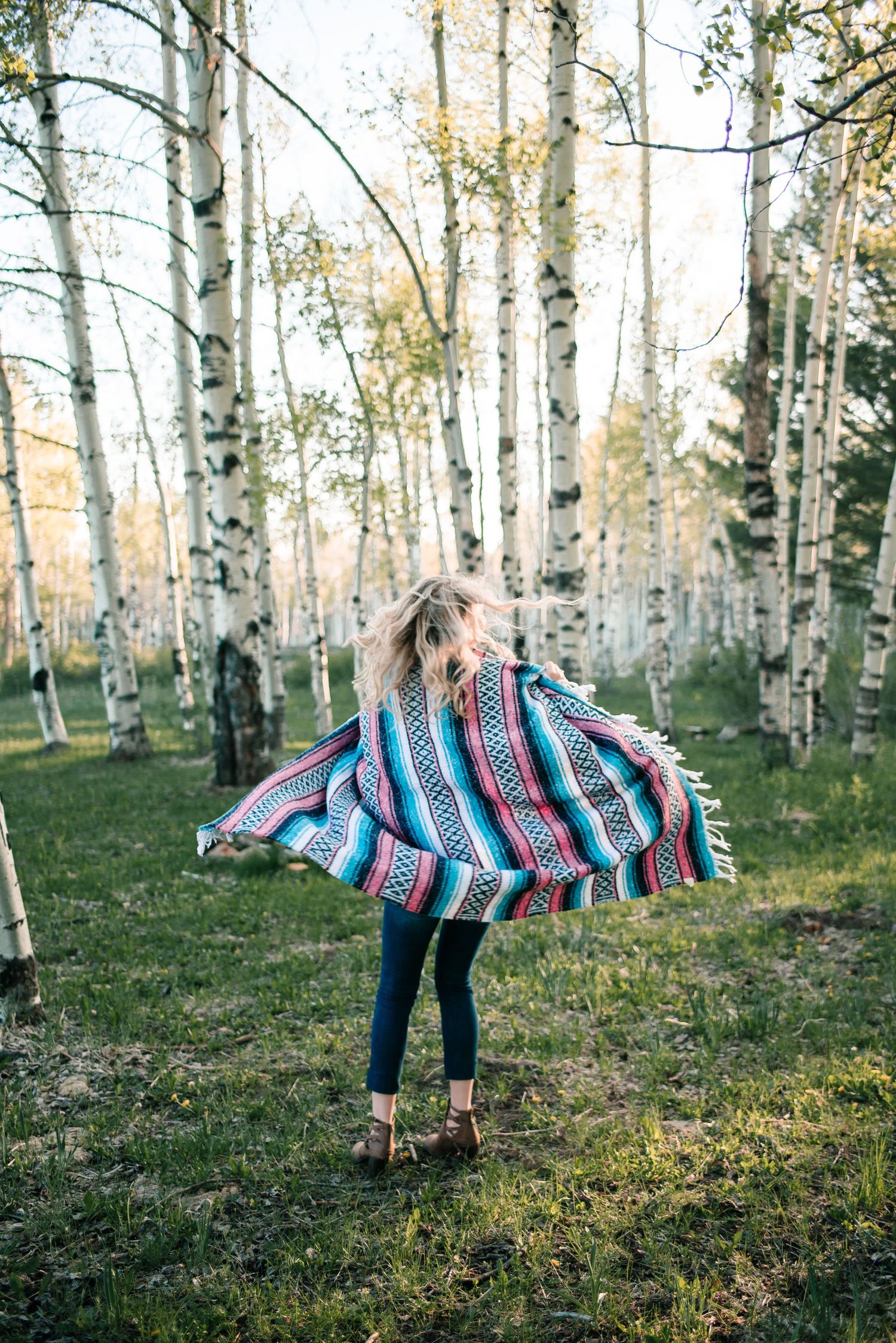 Playful movements with a striped blanket in a serene aspen grove during golden hour.