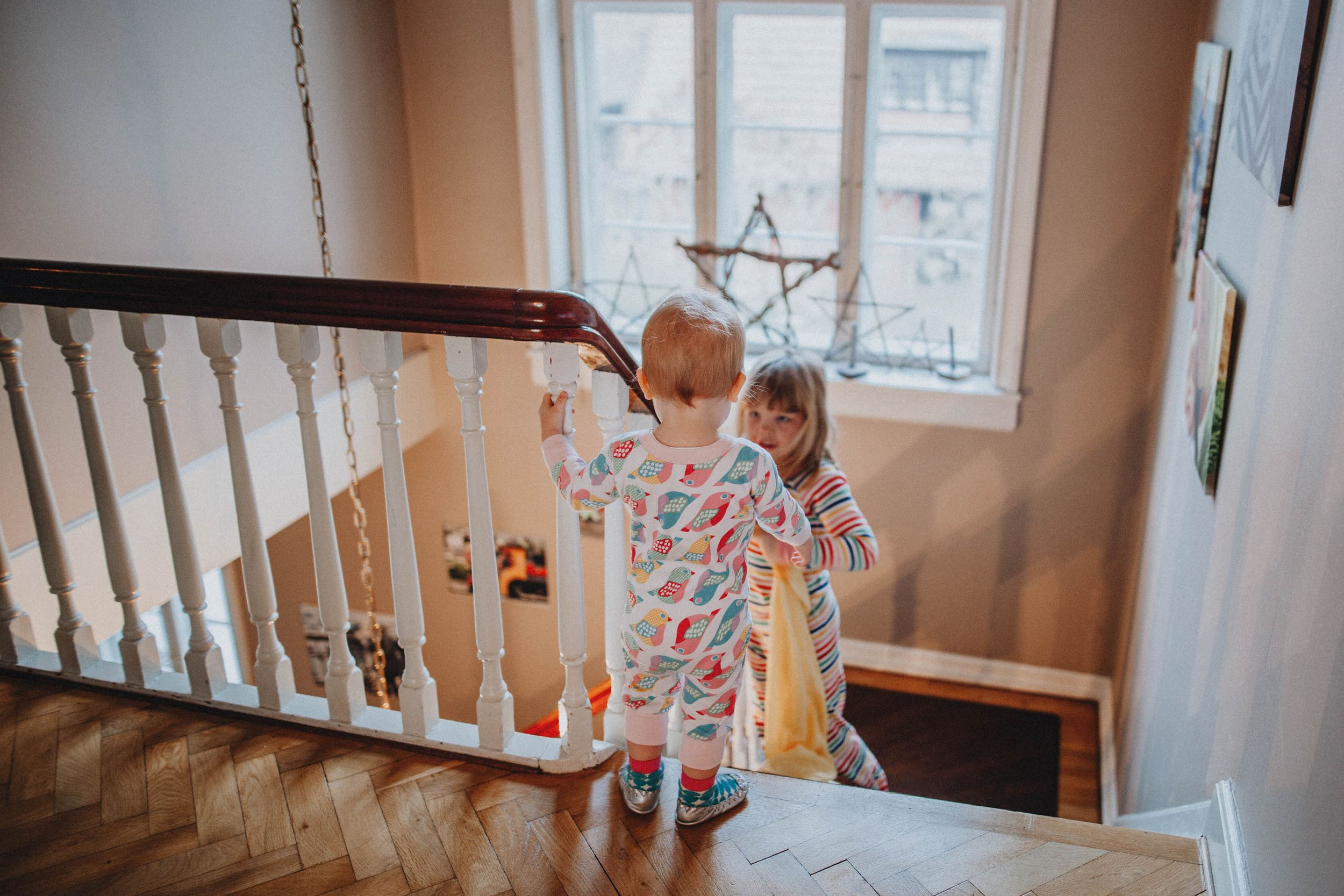 Lifestyle family photography indoors with natural light, capturing children’s humor, authenticity, and tender interactions.