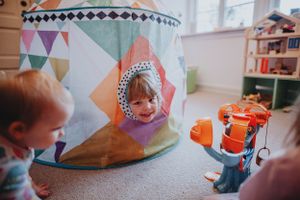 Family enjoying genuine and playful moments indoors with natural light, capturing children’s spontaneity and funny interactions.