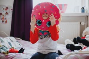 Family enjoying genuine and playful moments indoors with natural light, capturing children’s spontaneity and funny interactions.