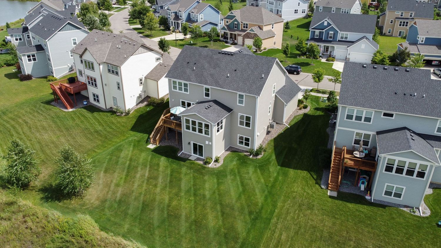Aerial view of suburban neighborhood showing well-maintained homes with manicured lawns.