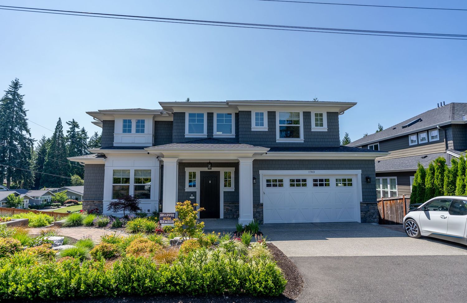 Modern craftsman home featuring white trim, attached garage, and drought-resistant landscaping.