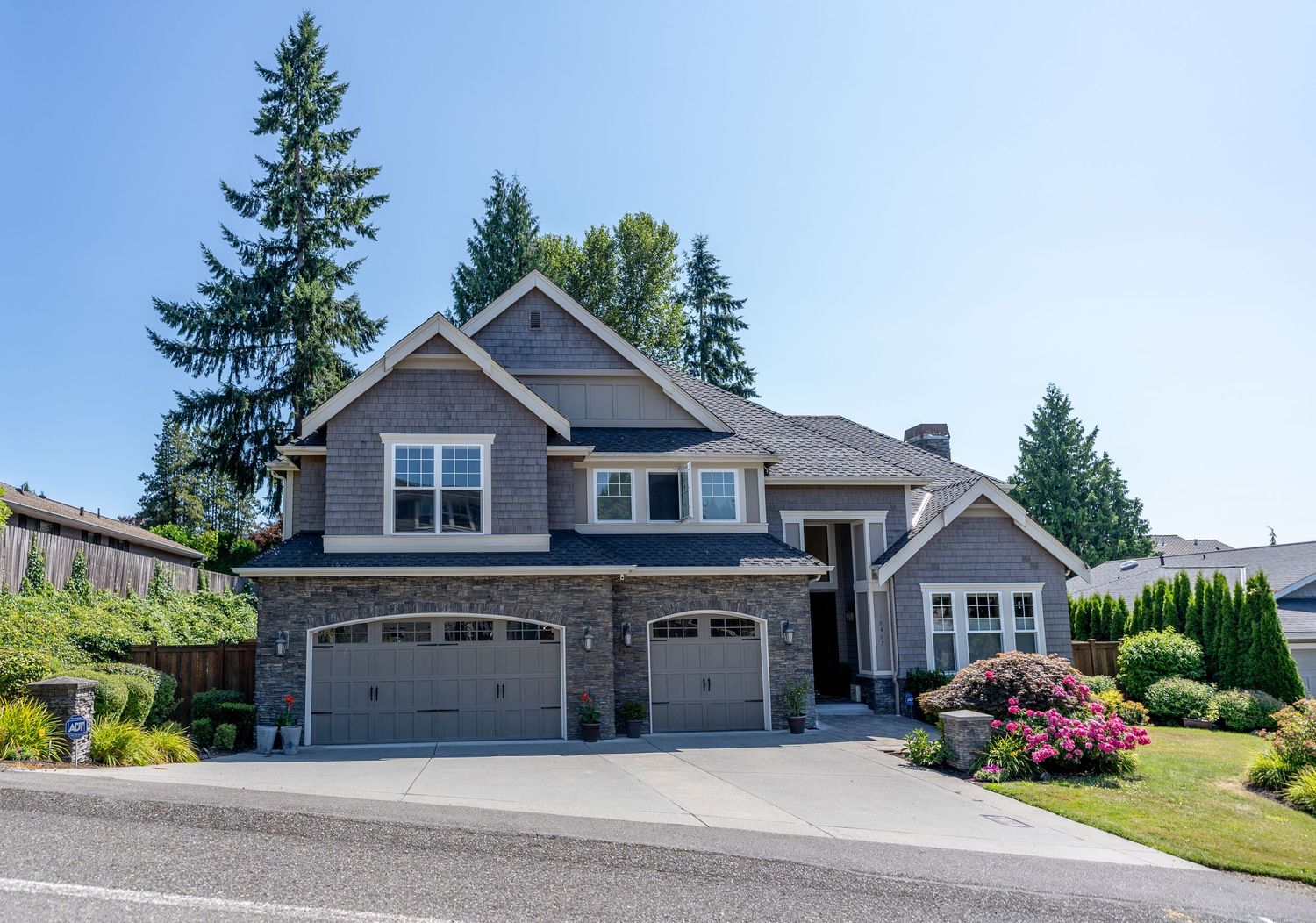 Elegant two-story suburban home with stone accents, double garage, and professional landscaping.