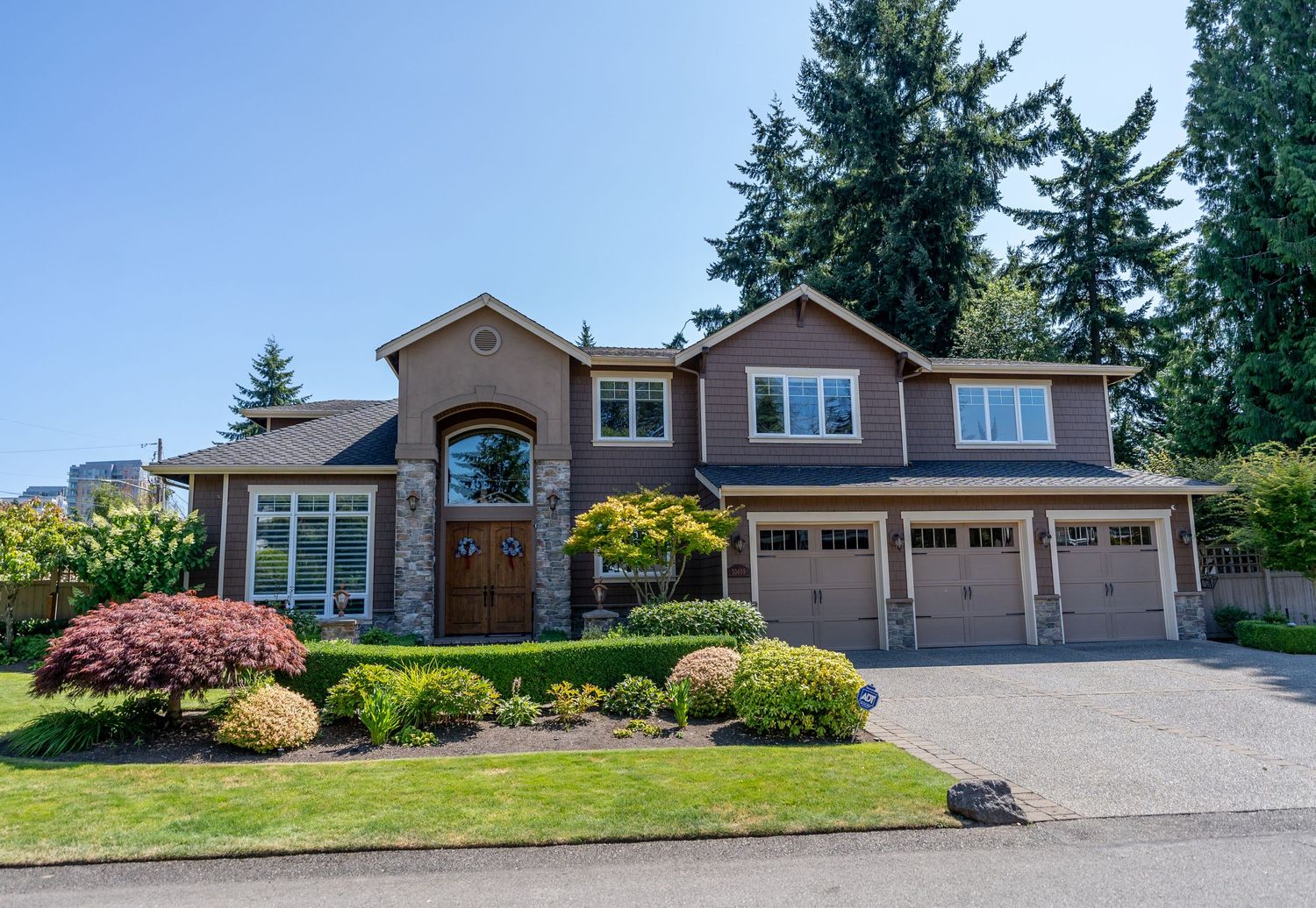 Mediterranean-inspired luxury home with arched entry, triple garage, and meticulously maintained gardens.