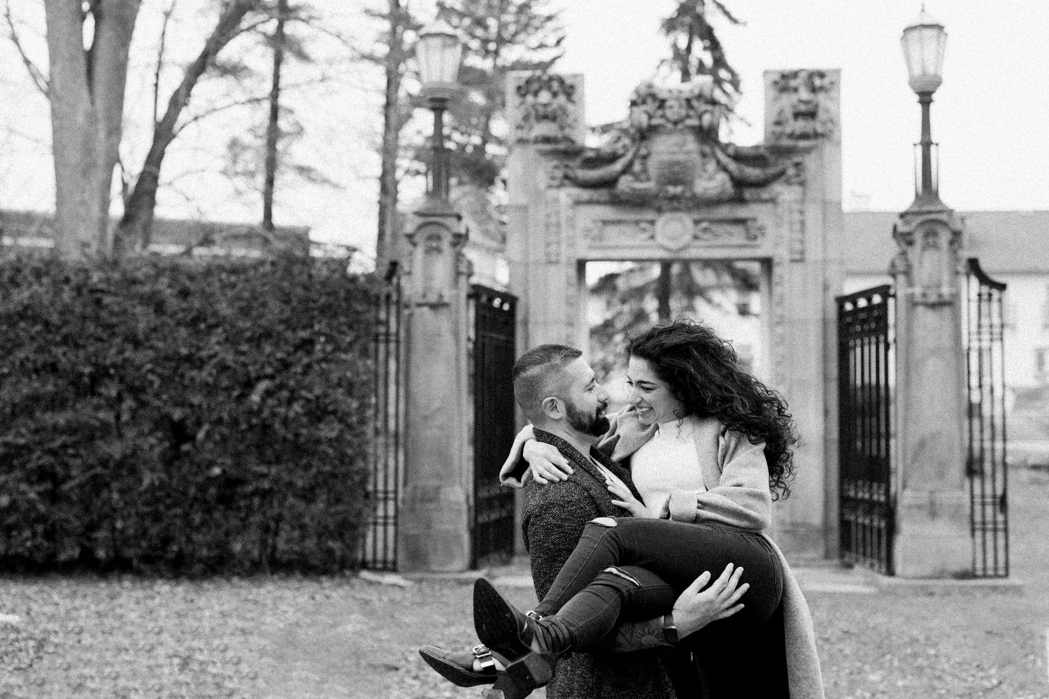 A man holds his partner in a bridal carry and she looks down at him smiling. Photo by Katie Crane.