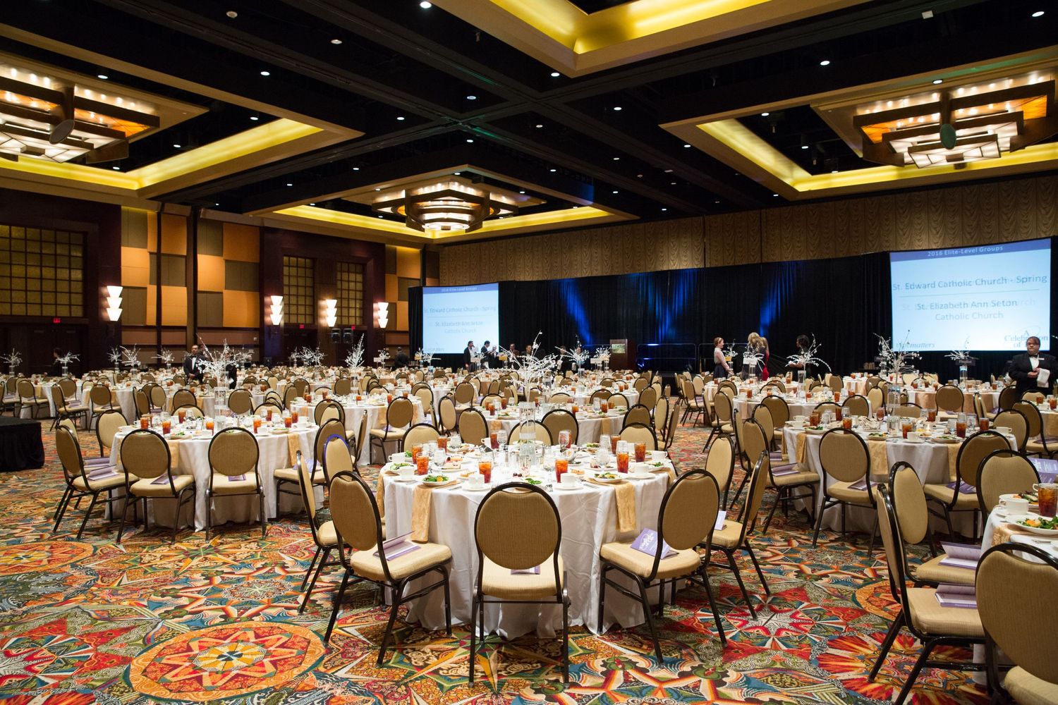 Large hotel ballroom set up with round tables and chairs for conference or banquet event.