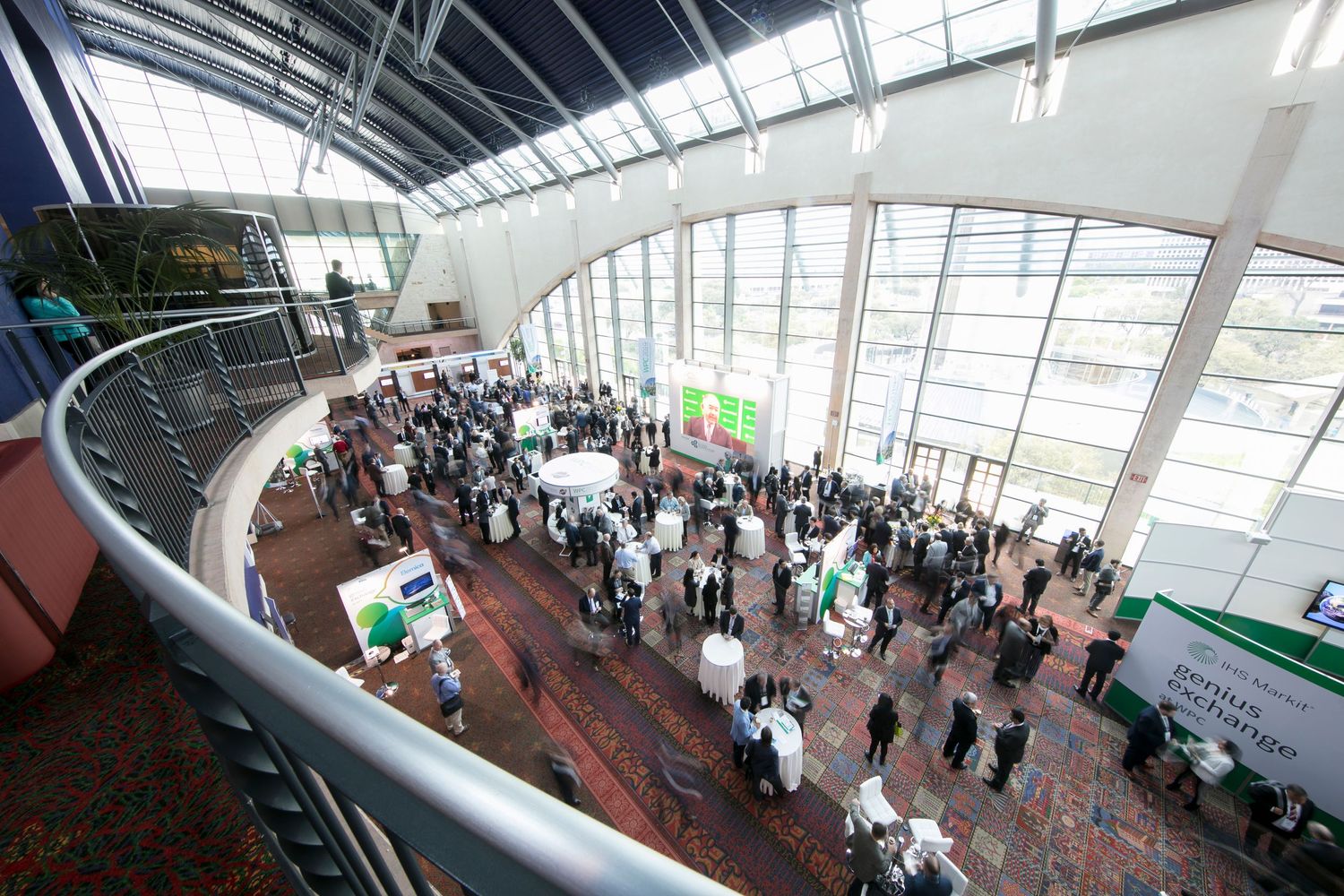 Elevated panoramic view of convention center floor filled with attendees.