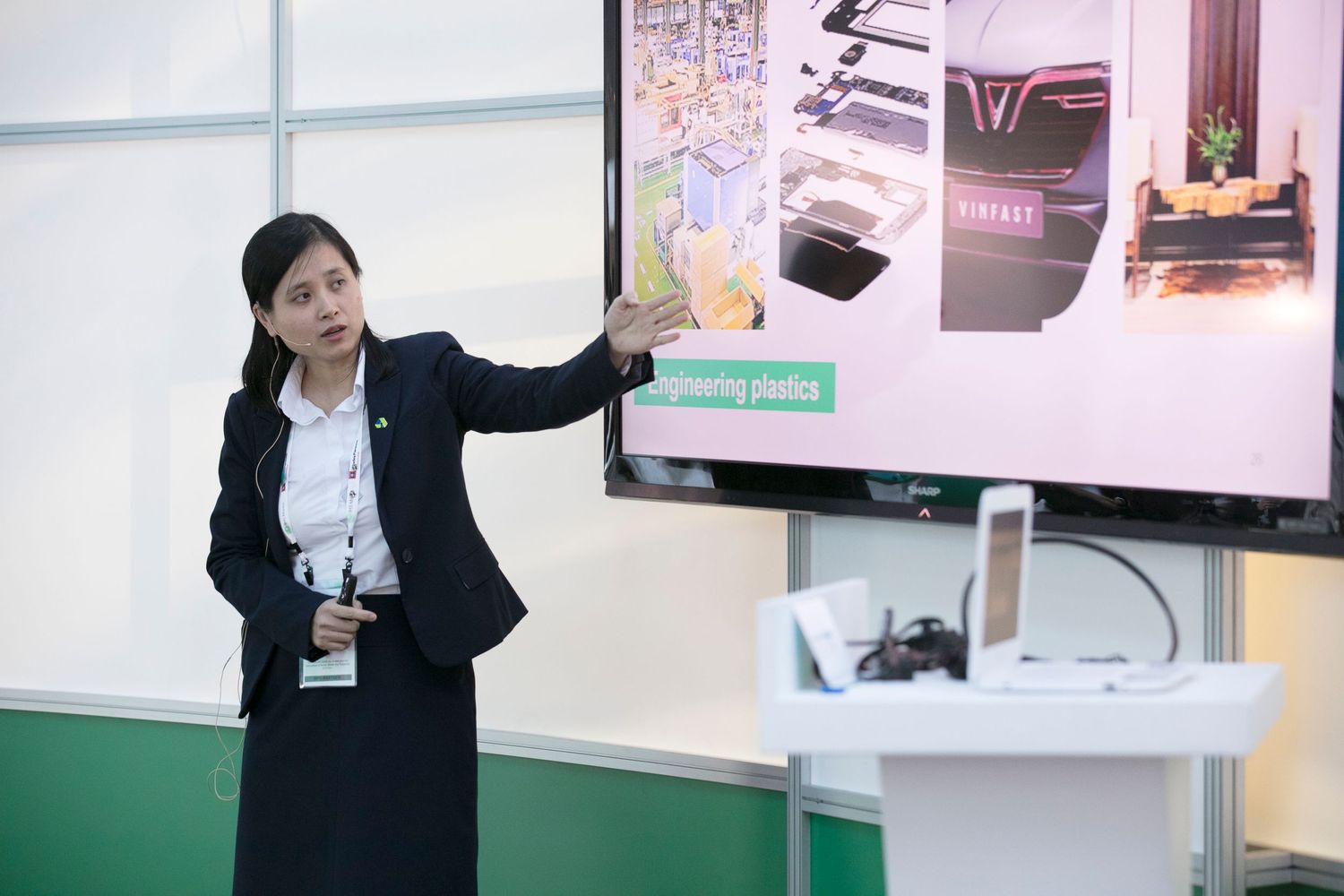 Corporate presentation space with digital displays and demonstration areas at trade show booth.