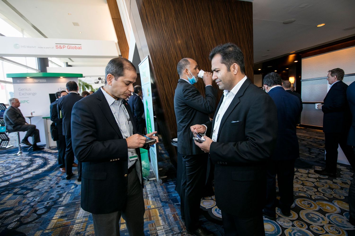 Attendees exchanging business cards and networking at a professional conference.