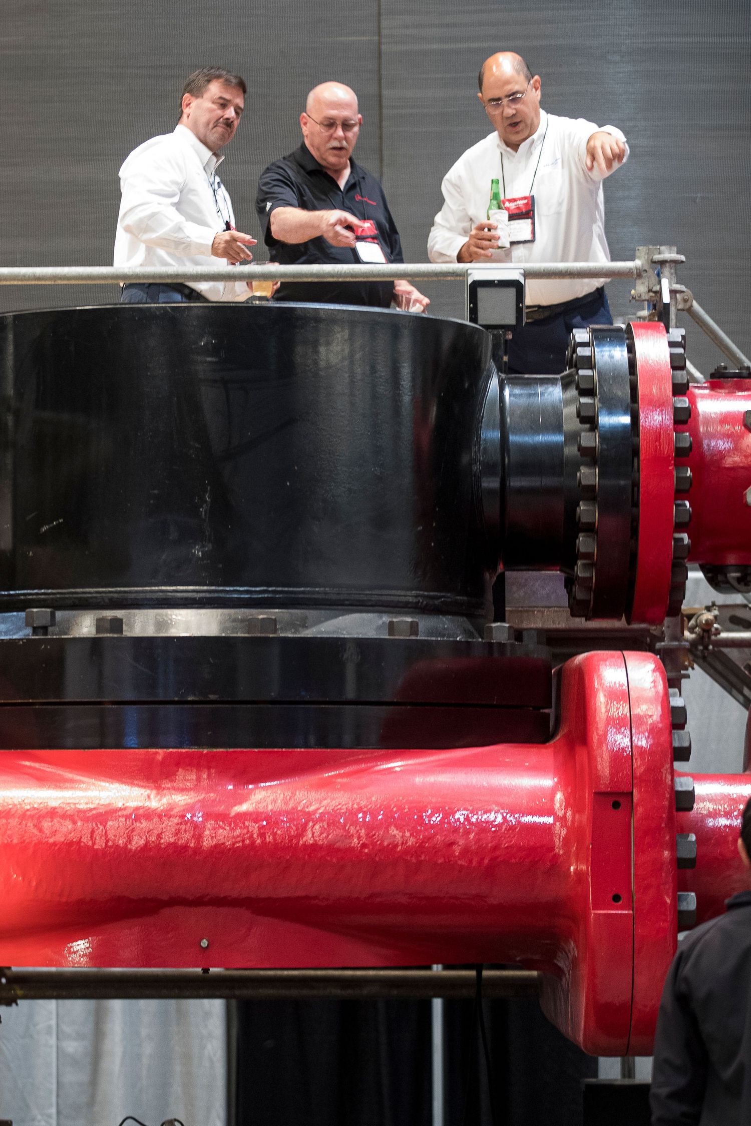 Close-up of industrial red pipe connections and fittings during technical inspection.